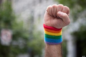 A man raises a fist while marching along the parade route during the San Francisco Pride parade in San Francisco, California on Sunday, June, 25, 2017. / AFP PHOTO / Josh Edelson